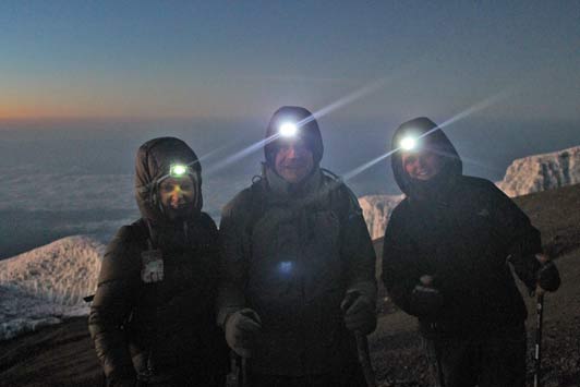 Personal transformation: headlights illuminate the path to the summit during the midnight ascent.