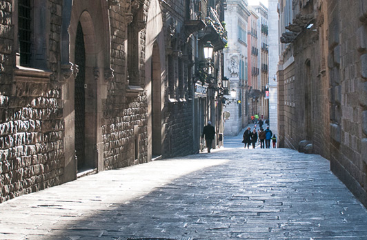 A narrow street slices through apartment buildings in the Gothic Quarter - a favorite spot on Barcelona walking tours.